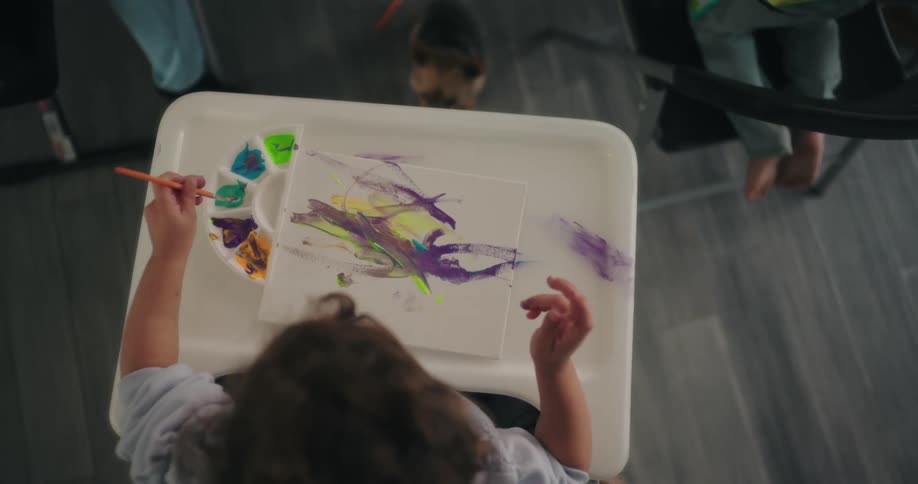 A child is painting with a brush