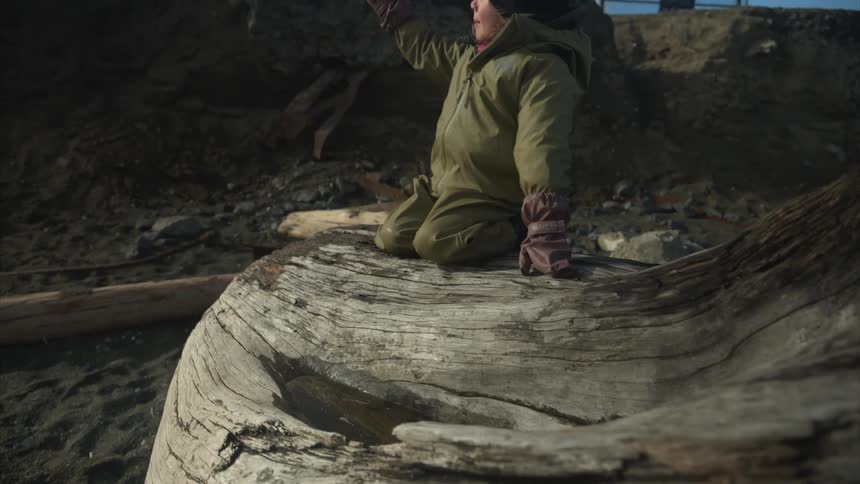 A child dips their glove in the water on the tree