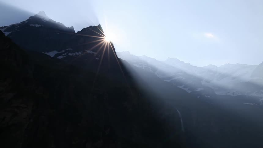 Sun rays appearing as sun rises over mountains