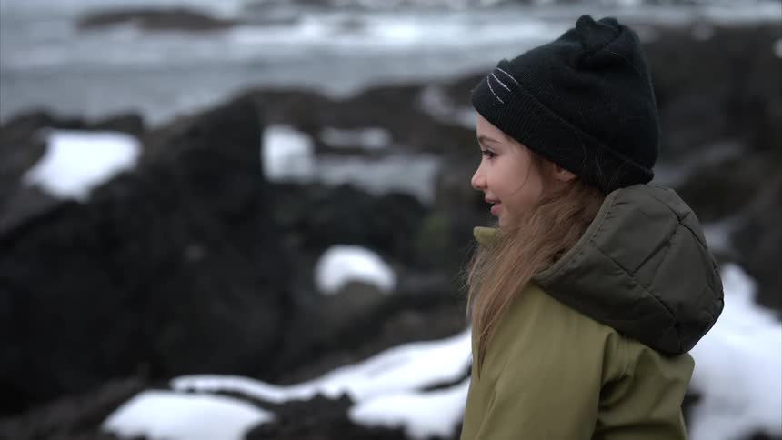 A girl is smiling on the shore