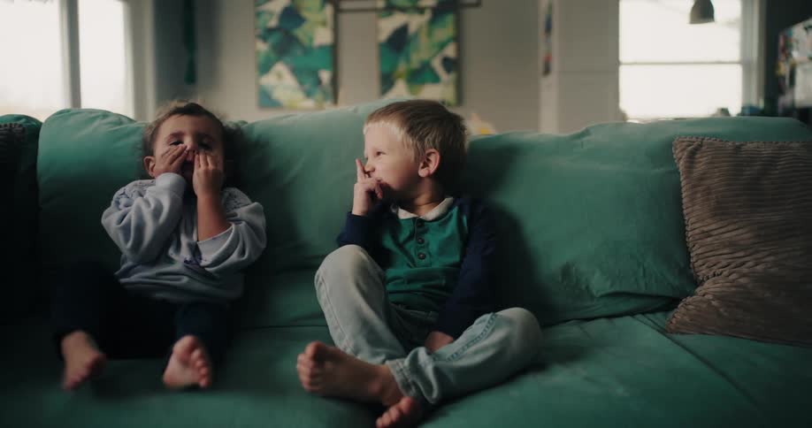Children make funny faces on the couch