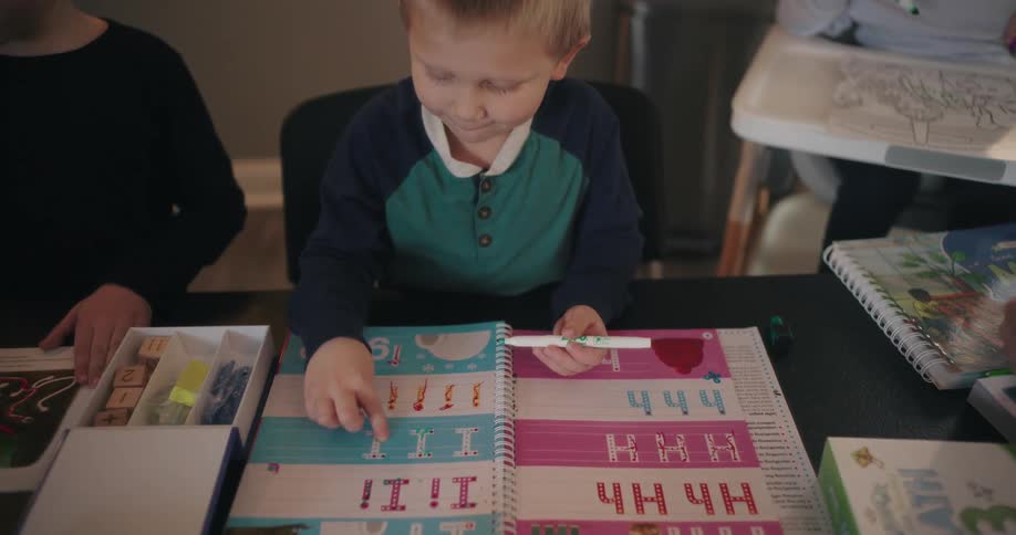 Children playing with coloring and activity books at home