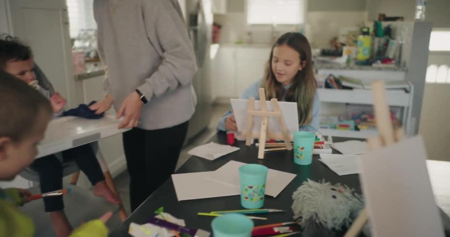 A woman is watching her family paint