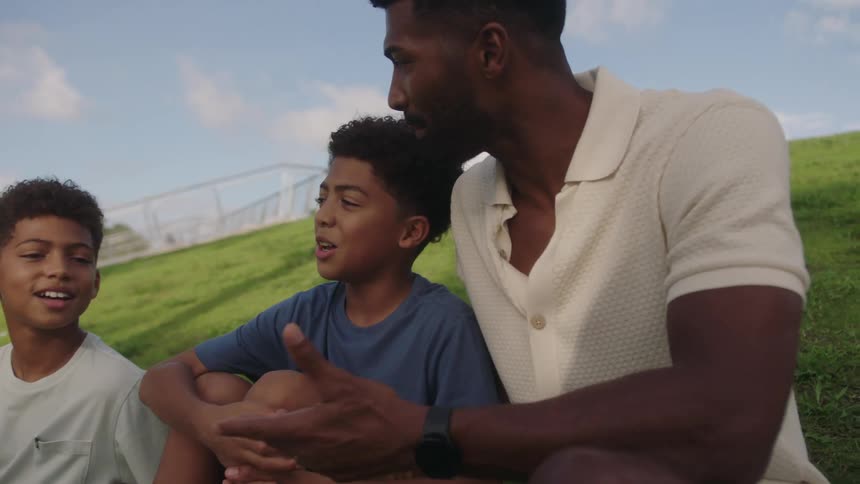A family talk and sit on a hill outside