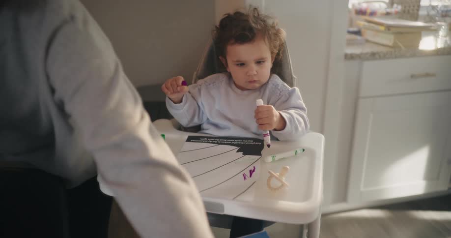 A mother helps her child draw