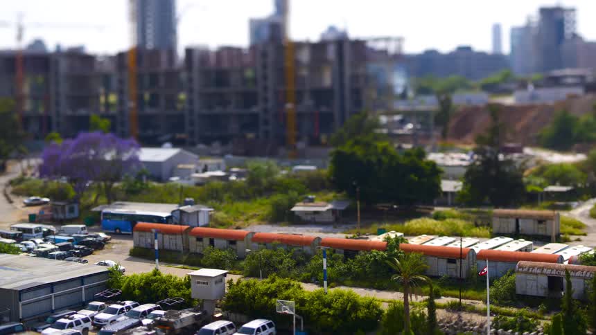 Parked cars buildings and trees make up a miniature hand crafted city