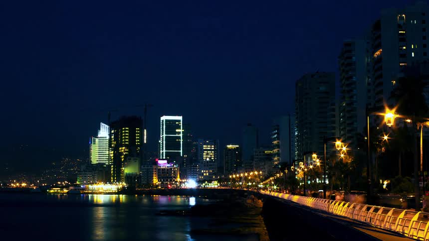 A stunning nighttime cityscape showcases illuminated skyscrapers reflecting on calm waters with a welllit promenade lined with streetlights adding depth and warmth to the urban skyline