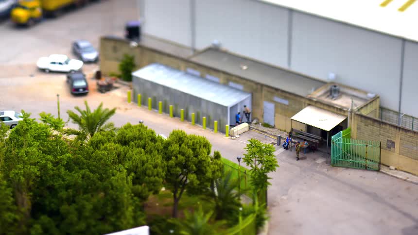 An aerial footage ofcars and trucks passing by a warehouse structure