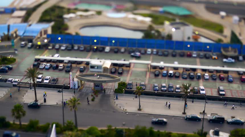 People and cars drive past the parking lot