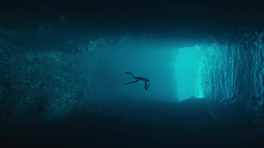 A scuba diver is videotaping in an underwater cave
