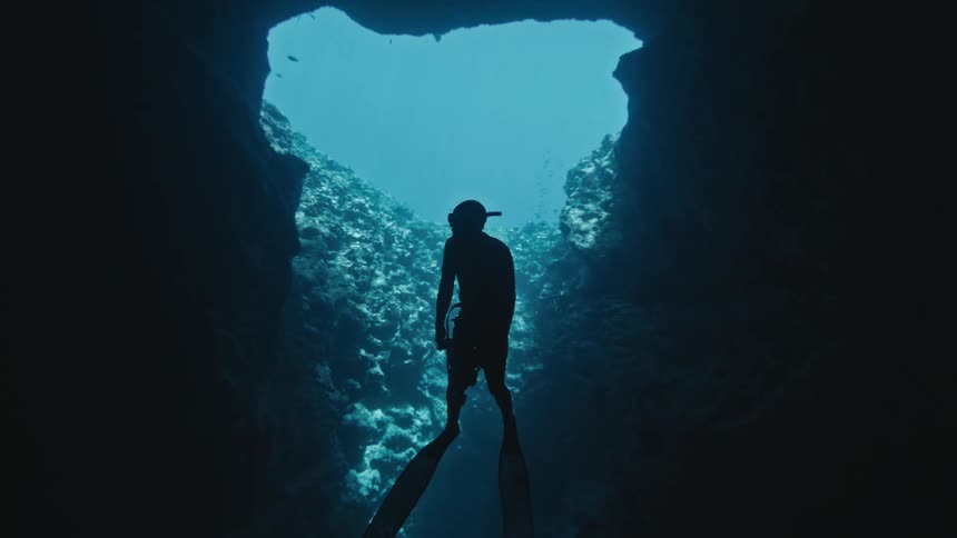 A diver is swimming in the underwater sea cave