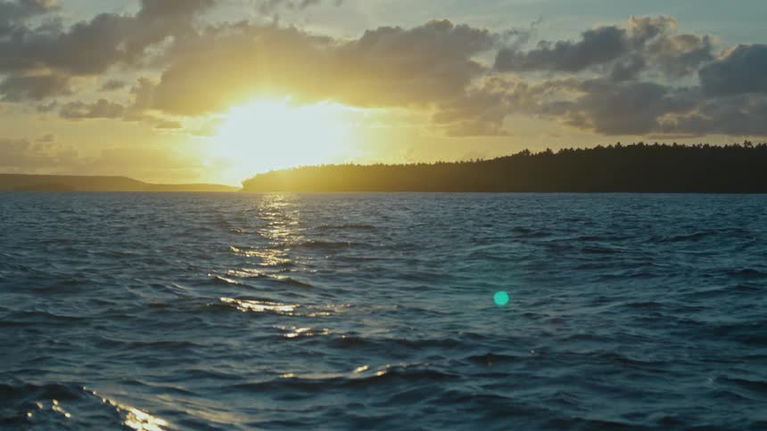 On a peaceful evening the sun sets above ocean water