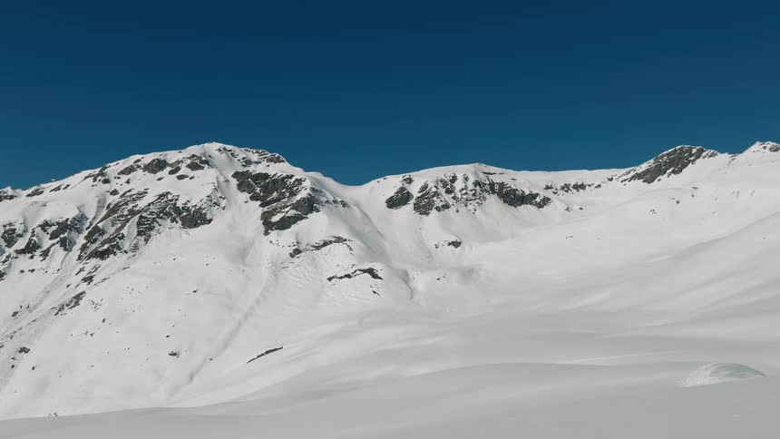 Helicopter flying over a snowy mountain valley