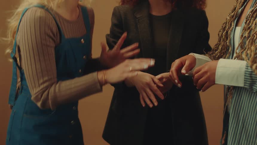 Female friends smile and discuss their bracelets