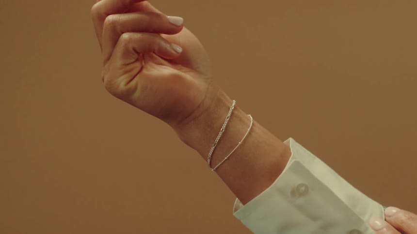 Wrist of a female arm with shiny bracelets