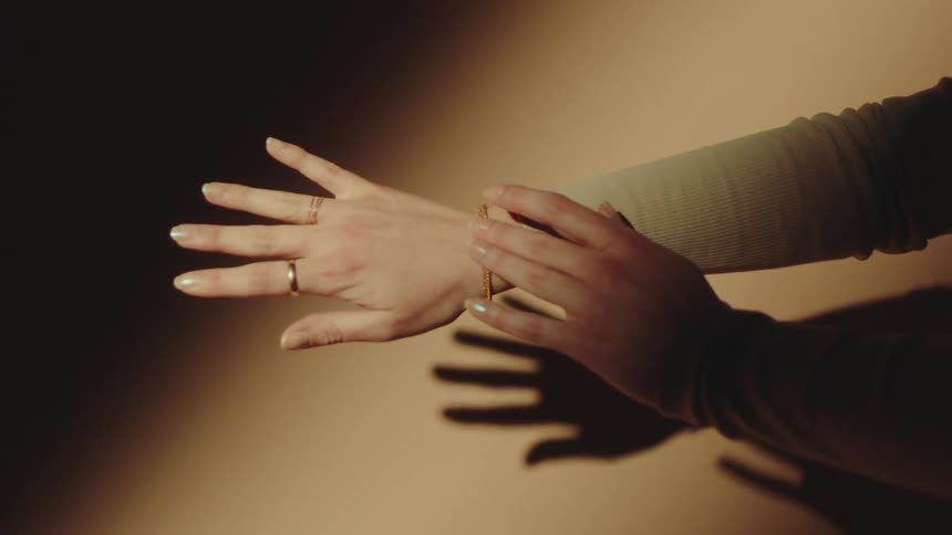 Female arm extended wearing a ring and a shiny bracelet