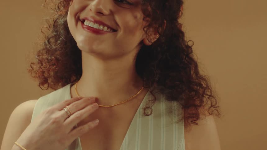 Smiling woman touches her necklace