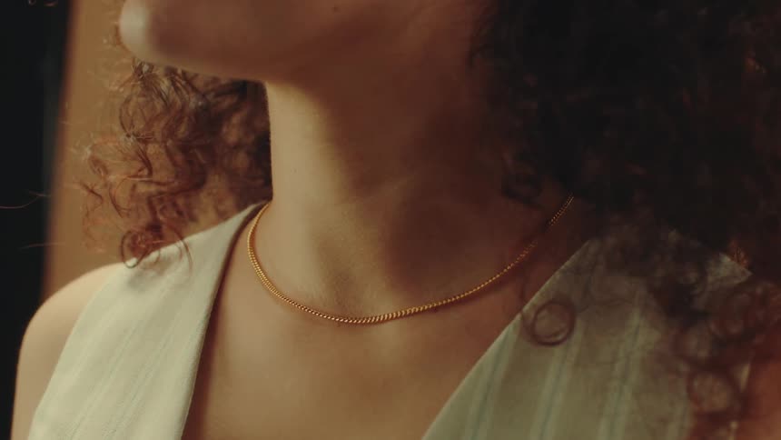 A woman is modeling a gold chain