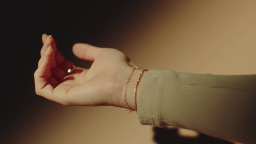 Woman is admiring multiple pieces of jewelry on her arm