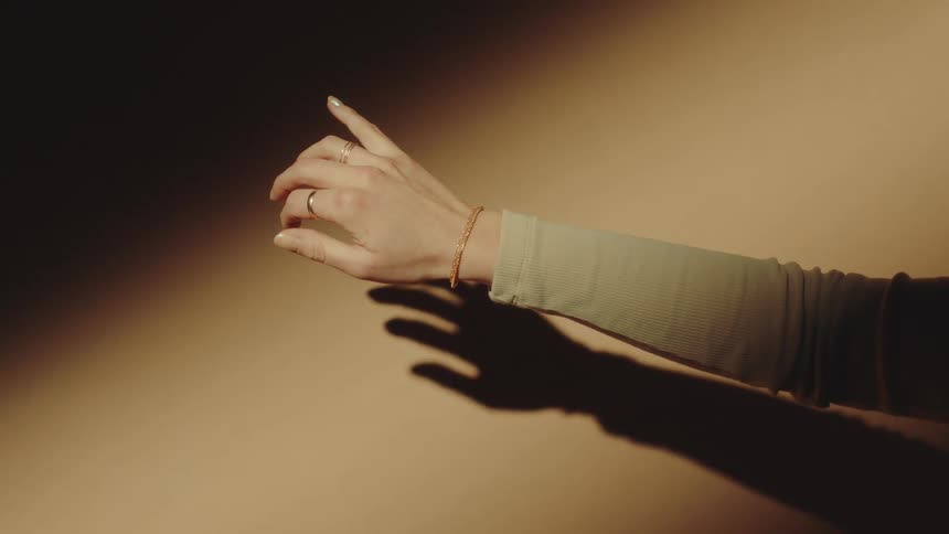 Female arm showing a golden bracelet against a light