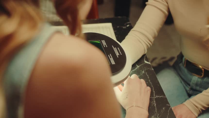 Woman using a tool on another persons wrist with a bracelet