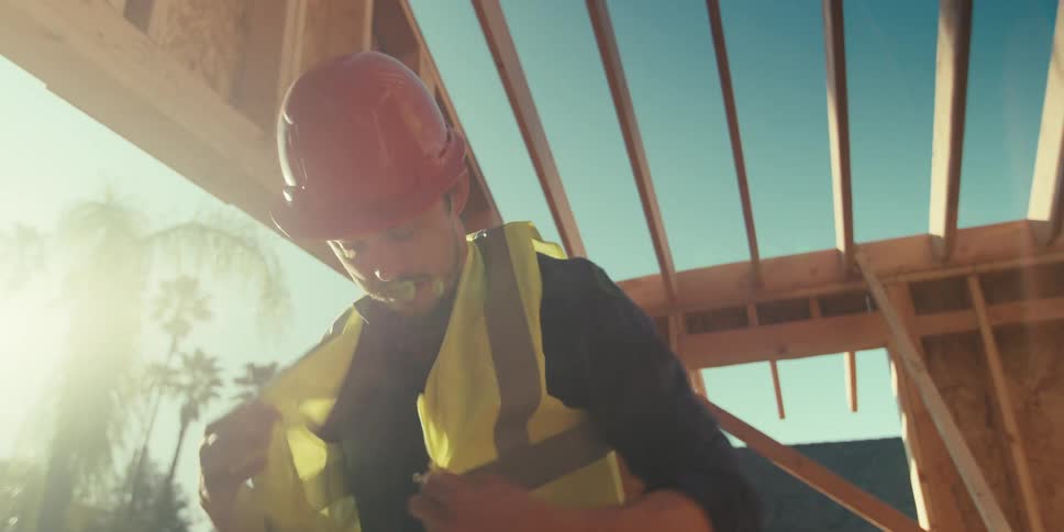 Male contractor putting on a safety vest on a job site