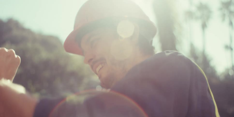 Man working on a construction site pries up a nail with a hammer on a sunny day