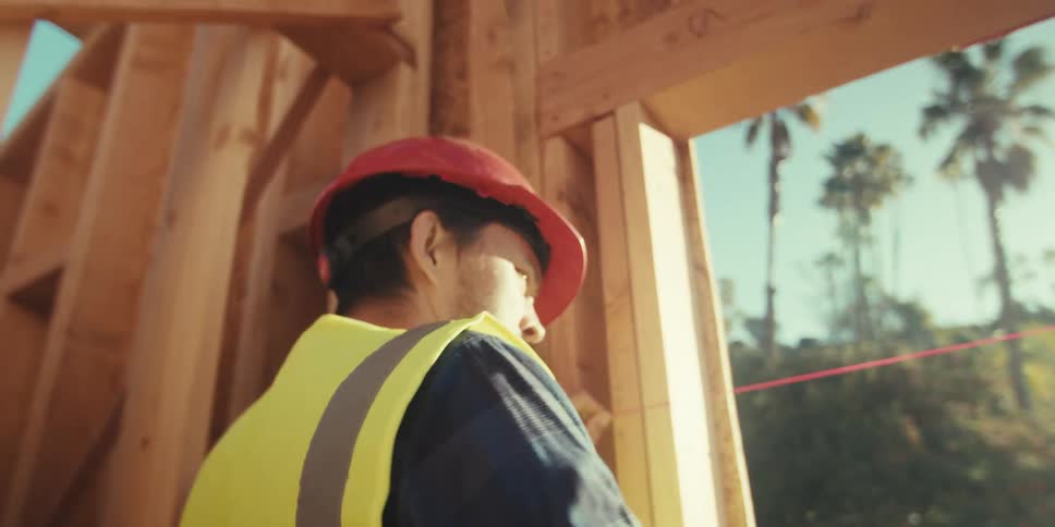 The worker measures the frame with a red twine