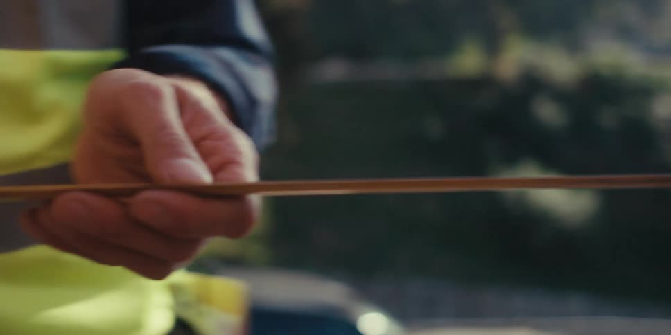 Close up of the hands of a construction worker measuring the distance of a wooden frame
