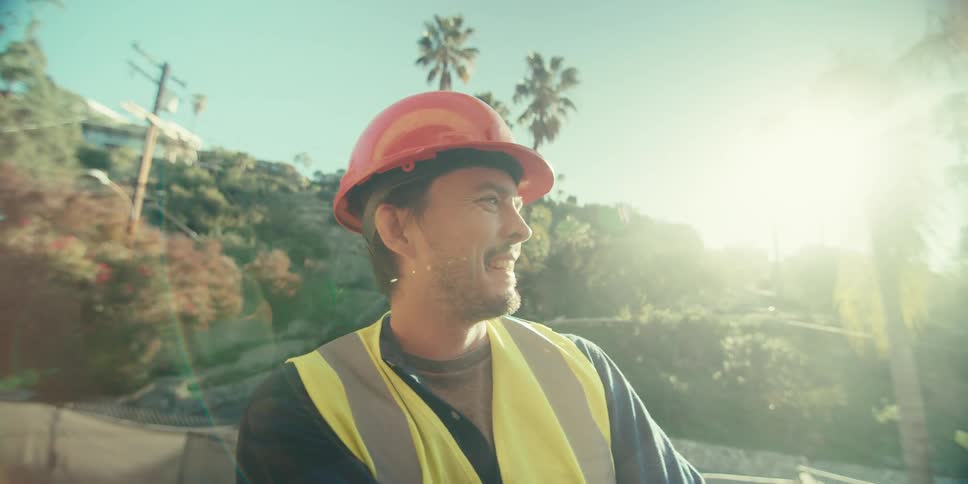 Smiling man while wearing a red protective helmet