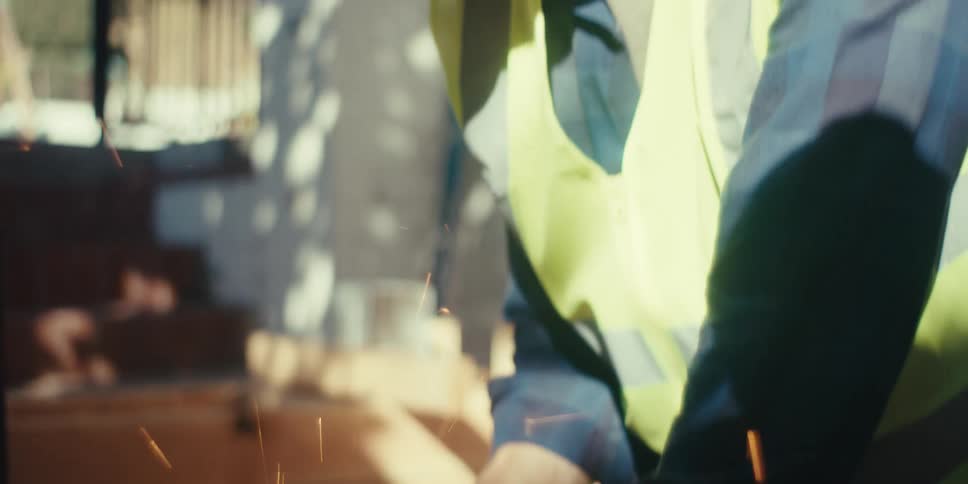 A construction worker is using a power saw