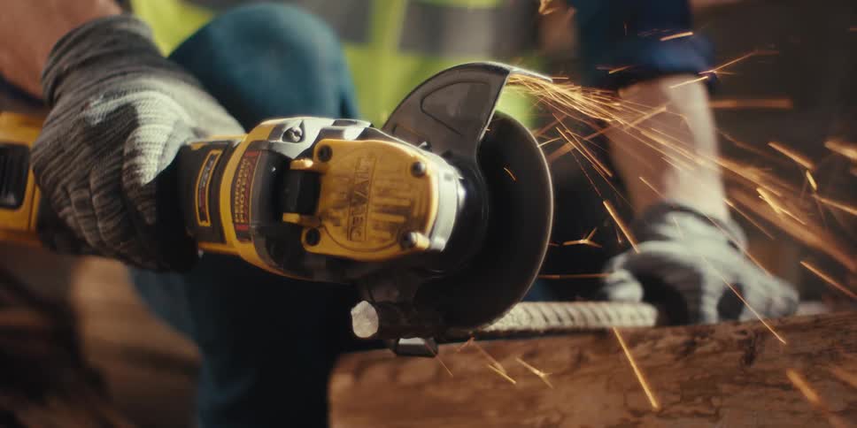 A man is cutting rebar with an angle grinder