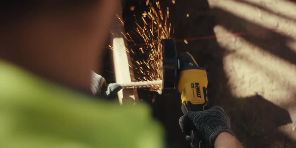 Worker operating a cutting tool on metal with sparks coming out