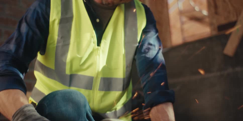 A laborer grinding a piece of rebar