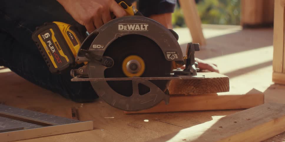 A person uses a dewalt circular saw to cut a piece of wood in a construction site