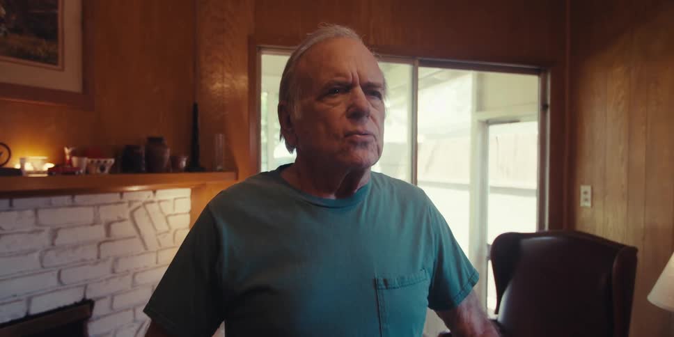 Elderly man standing in living room taking deep breaths