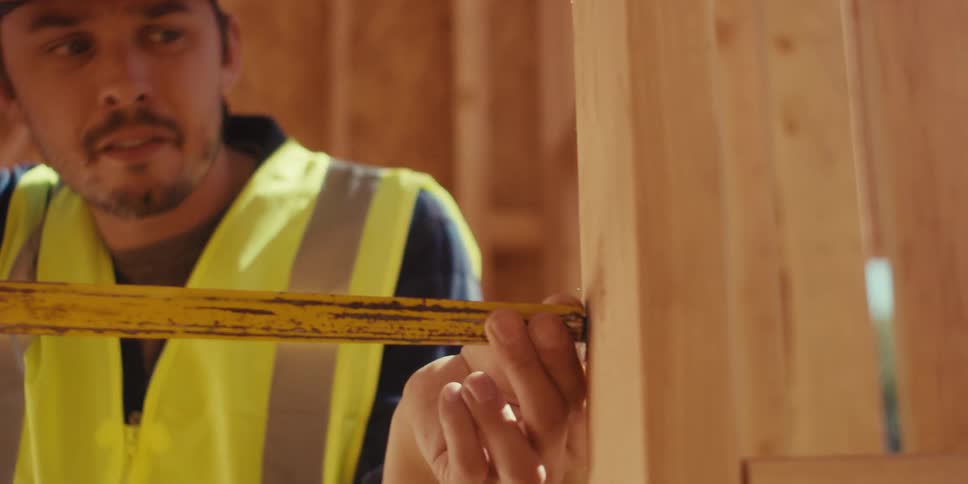 Man in hard hat and vest entering early stage construction site and inspecting