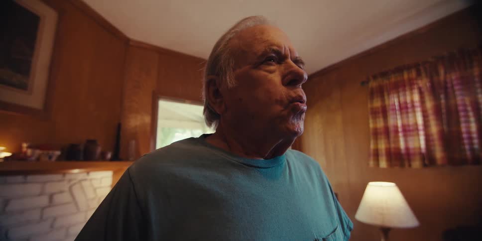 An elderly man doing breathing exercises in his living room