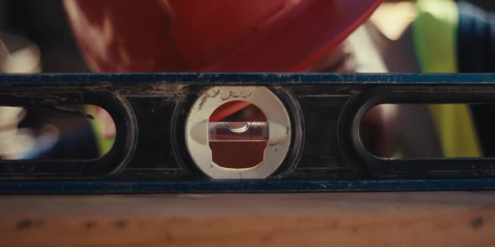 A construction worker uses a leveler