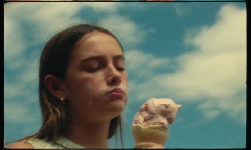 Woman with dirty face sucking ice cream