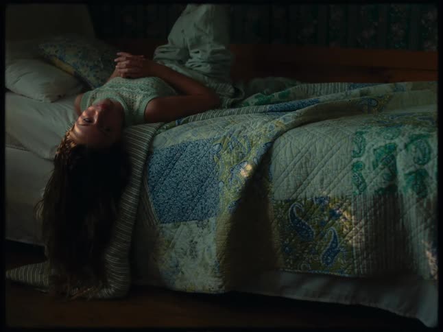 A womans head is hanging off the bed