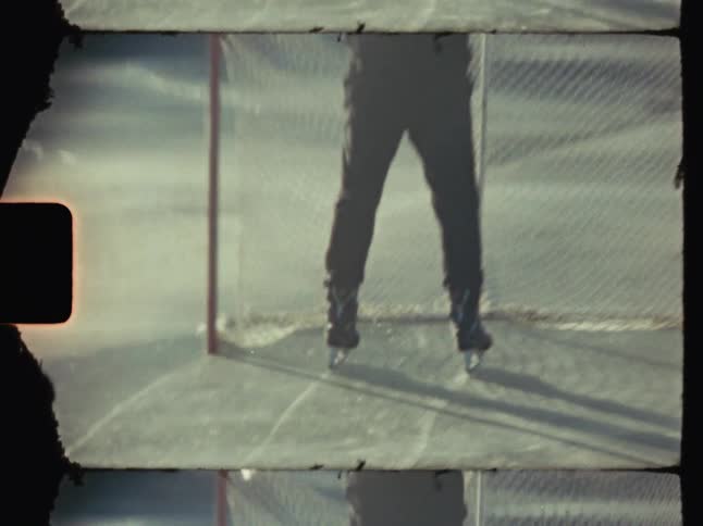 A hockey player moving a net into position on the ice