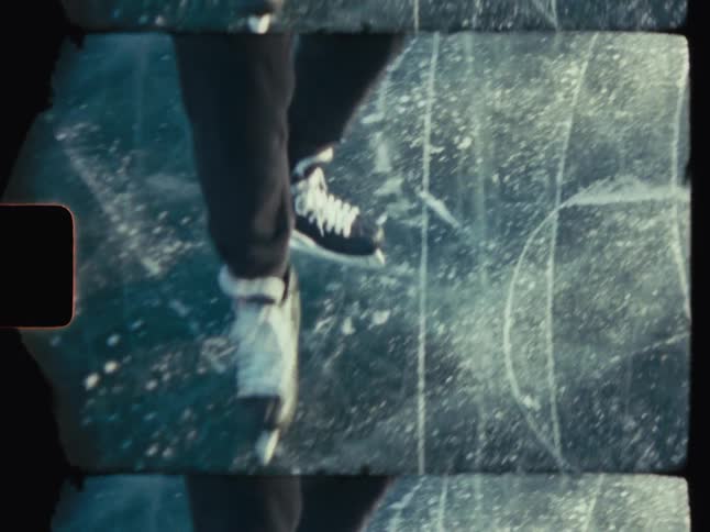 A pair of ice skates gliding across a textured translucent ice surface