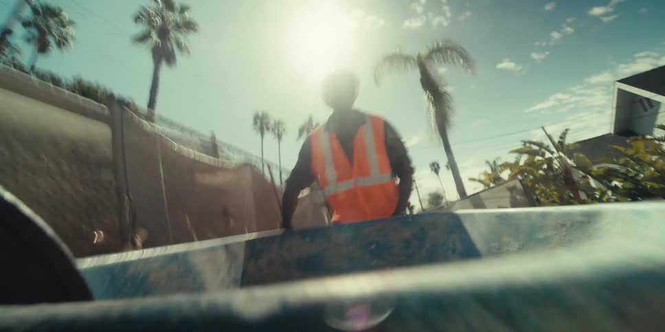 A construction worker pushes a wheelbarrow on a sunny day