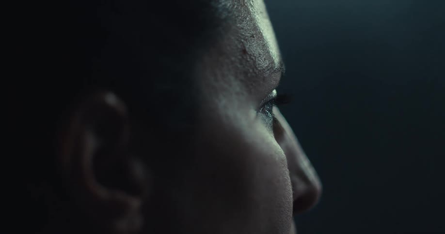 A woman looks around and tilts her head