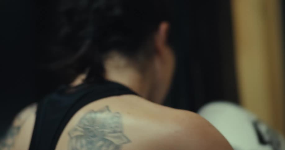 A woman is punching and kicking a heavy bag
