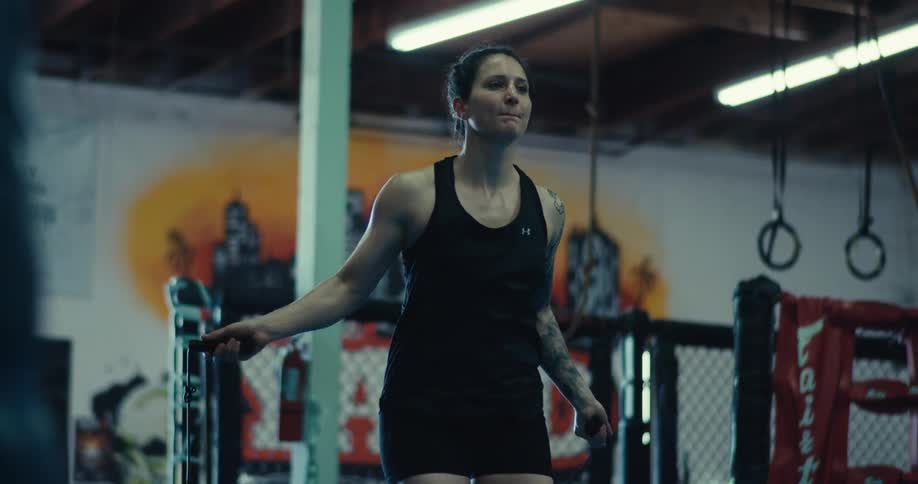 Concentrated woman jumping rope while in a boxing gym