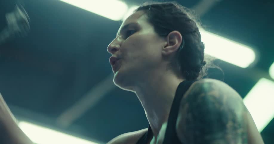 Woman exercises with battle ropes in a brightly lit gym