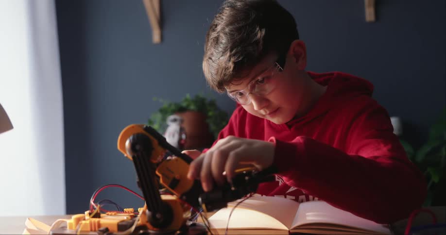 A boy tinkering with a piece of robotics