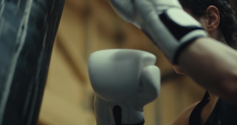 A footage of a lady boxing a punching bag